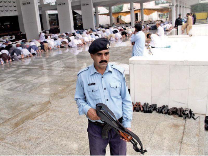 police official stands alert during eid prayers photo file