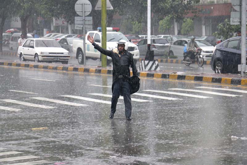 a motorcyclist is hit by a rickshaw he is trying to overtake top a warden manages traffic during heavy rain on the mall above photo shafiq malik