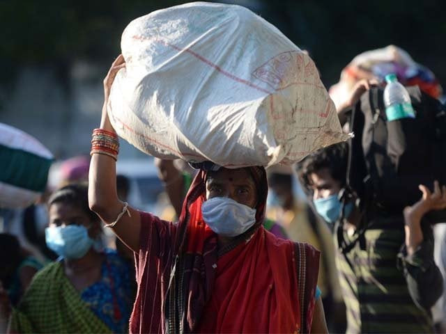 stranded migrant labourers walk carrying their belongings to board a special train photo afp
