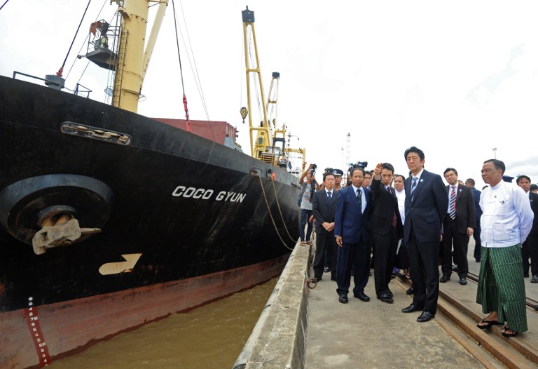 japanese prime minister shinzo abe r visits the myanmar international terminals thilawa mitt port on the outskirts of yangon on may 25 2013 photo afp