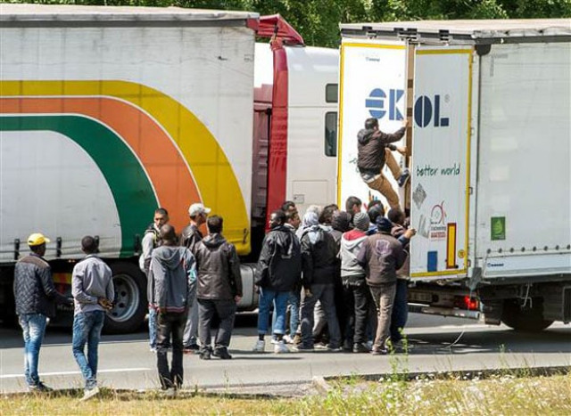 migrants climb in the back of a truck tuesday on the a16 highway heading to the eurotunnel in calais in northern france photo afp migrants climb in the back of a truck tuesday on the a16 highway heading to the eurotunnel in calais in northern france photo afp