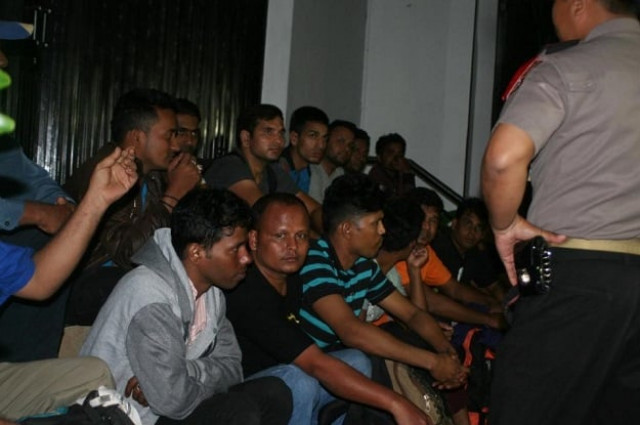 indonesian police in in sukabumi stand next to a group of migrants arrested after being found stranded in the waters off java island when their boat ran out of fuel as they tried to reach australia on september 23 2015 photo afp indonesian police in in sukabumi stand next to a group of migrants arrested after being found stranded in the waters off java island when their boat ran out of fuel as they tried to reach australia on september 23 2015 photo afp