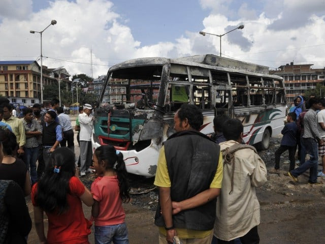 nepalese bystanders gather around the charred remains of a bus which was set alight during a general strike call by the hardline breakaway faction of former maoist rebels communist party of nepal maoist in kathmandu on september 20 2015 photo afp nepalese bystanders gather around the charred remains of a bus which was set alight during a general strike call by the hardline breakaway faction of former maoist rebels communist party of nepal maoist in kathmandu on september 20 2015 photo afp
