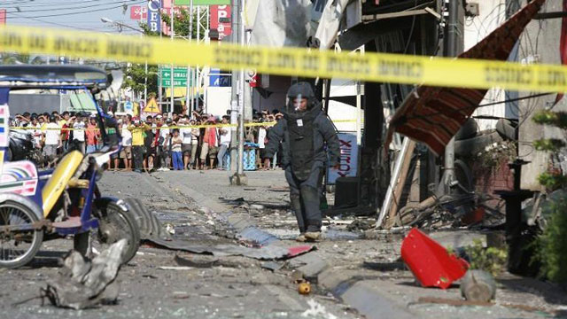 a bomb disposal officer walks among the wreckage after a bomb exploded outside a bus station in zamboanga southern philippines on jan 23 2015 photo afp