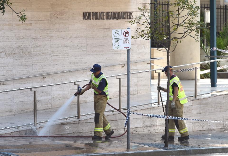a fireman hoses down the scene where a 15 year old gunman shot dead a civilian police employee the previous day before being himself gunned down by police in sydney on october 3 2015 photo afp