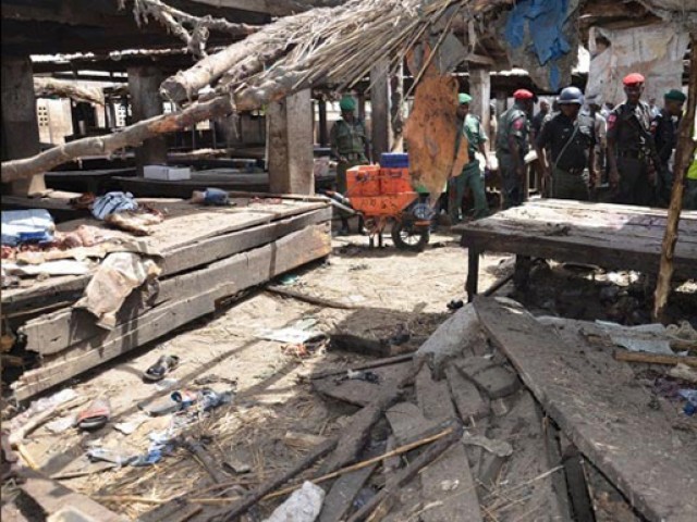 policemen inspect the site of a suicide attack at a busy cattle market in nigerian city of maiduguri on tuesday photo afp