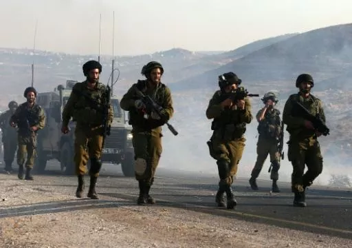 an israeli soldier aims his weapon at palestinian protesters during clashes on a street leading to duma village on august 1 2015 photo afp an israeli soldier aims his weapon at palestinian protesters during clashes on a street leading to duma village on august 1 2015 photo afp
