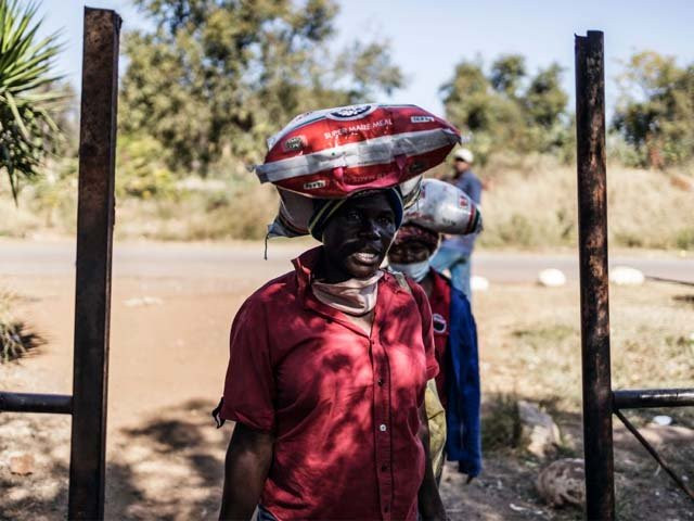 residents of an informal settlement in pretoria leave with bags of food following a food distribution drive photo afp residents of an informal settlement in pretoria leave with bags of food following a food distribution drive photo afp