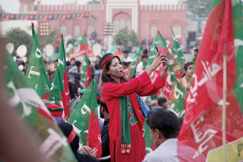 a pti supporter uses the time between speeches to take her photograph photo shafiq malik express