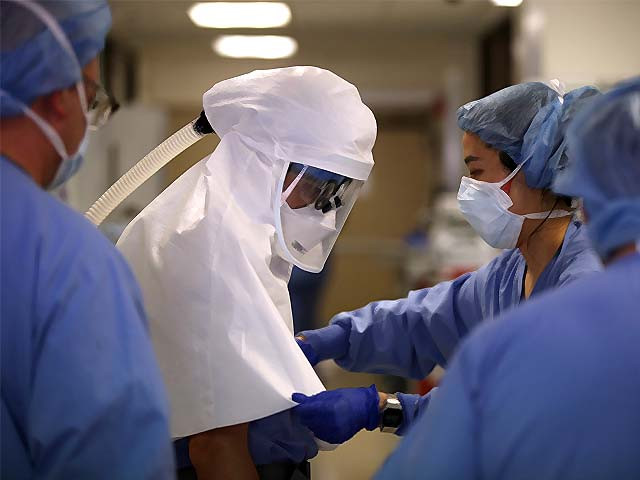 a nurse helps a doctor remove his personal protective equipment ppe photo afp a nurse helps a doctor remove his personal protective equipment ppe photo afp