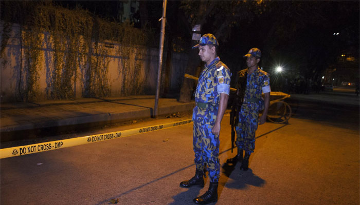 bangladeshi police officers stand guard on september 28 2015 at the site where an italian charity worker has died after being shot by attackers in dhaka photo afp