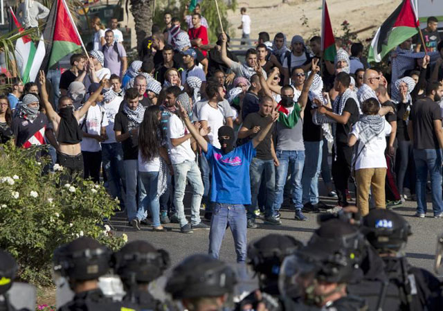 arab israeli protesters flash the sign of victory in front of israeli security forces during a rally in solidarity with palestinian prisoners held in israeli jails on june 27 2017 in the northern israeli town of umm al faham photo afp