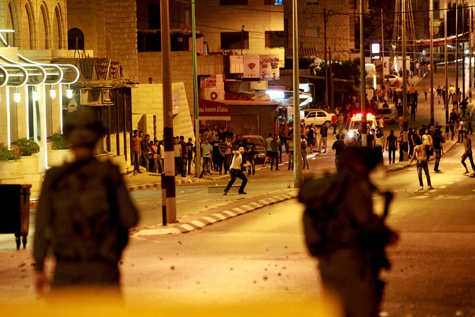 in this file photo palestinian protesters throw stones towards an israeli military observation tower at a section of the separation barrier to the main entrance of the west bank city of bethlehem on july 2 2014 photo afp