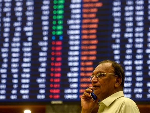 a stockbroker talks on his cellphone as he watches the latest share prices photo afp a stockbroker talks on his cellphone as he watches the latest share prices photo afp