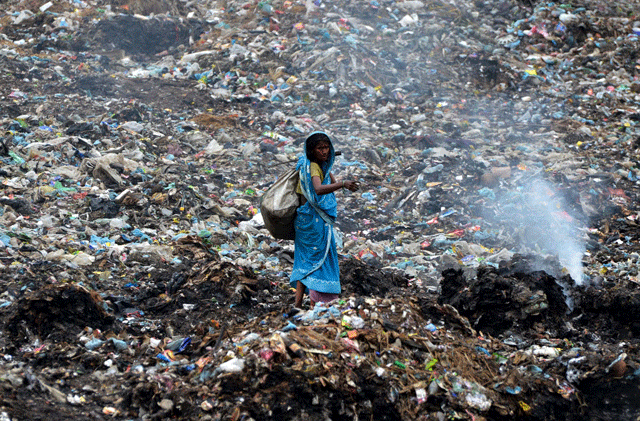 an indian ragpicker walks among heaps of rubbish at a municipal waste dump in dimapur on world earth day photo afp