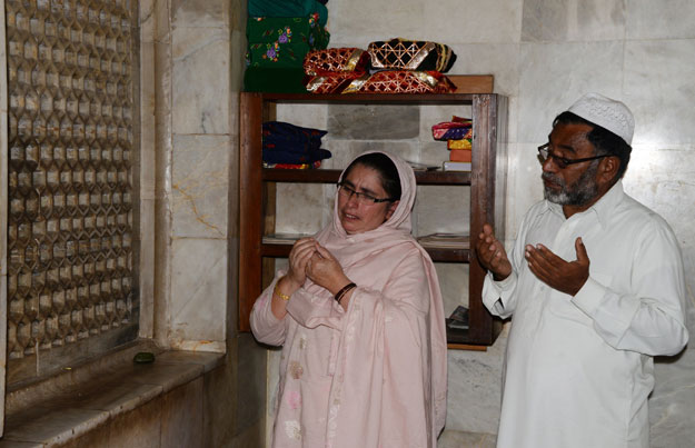 parents of nazish naz who went missing in the 2005 kashmir earthquake pray for their daughter at a shrine at a shrine in mera tanolian in muzaffarabad photo afp