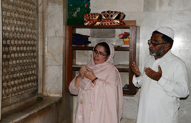 parents of nazish naz pray for their daughter at a shrine in mera tanolian in muzaffarabad photo afp