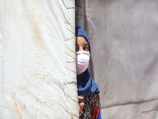 a syrian girl wearing a medical mask is seen at a refugee camp where thousands of displaced syrians shelter photo afp a syrian girl wearing a medical mask is seen at a refugee camp where thousands of displaced syrians shelter photo afp