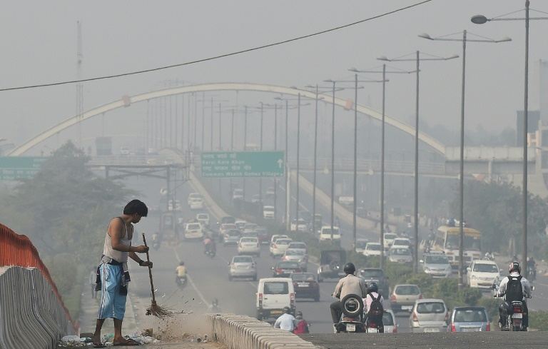 an indian sweeper cleans a flyover as smog covers the capital 039 s skyline the morning after celebrations for the diwali festival in new delhi on october 24 2014 photo afp