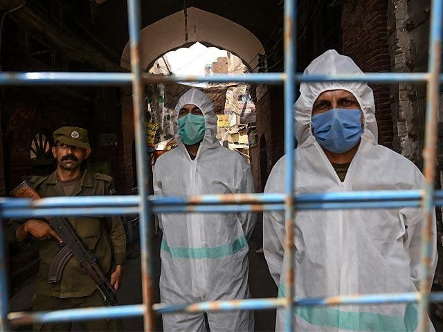 policemen wearing gear stand guard behind a barricade at a restricted area sealed by the authorities in lahore photo afp policemen wearing gear stand guard behind a barricade at a restricted area sealed by the authorities in lahore photo afp