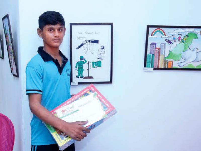 thirteen year old ali posing with his painting showcased at the two day exhibition art beat national child art competition and exhibition organised by the little art at arts council of pakistan karachi photo courtesy the little art