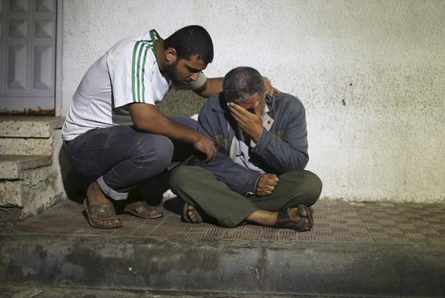 relatives react outside a hospital morgue after a three year old palestinian girl and her mother were killed after their house was brought down by an israeli air strike in gaza early on october 11 2015