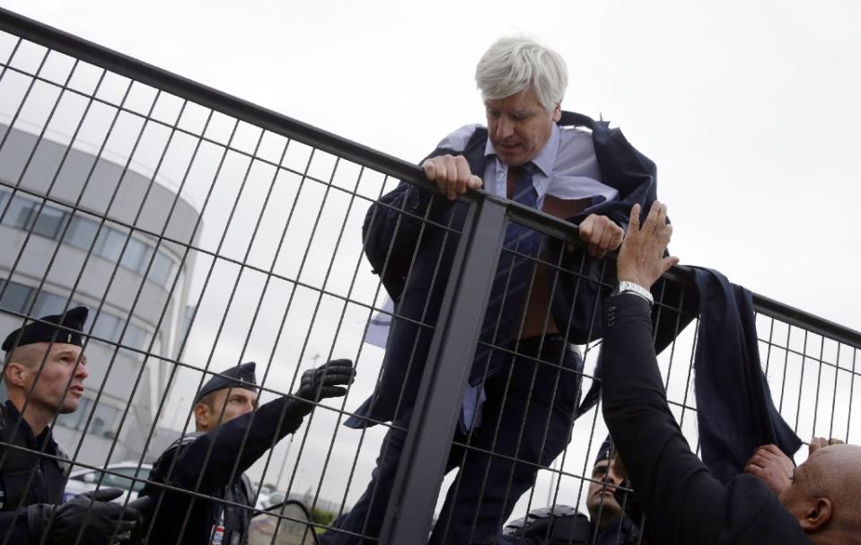 director of air france in orly pierre plissonnier nearly shirtless tries to cross a fence after several hundred employees invaded the offices of air france in roissy en france on october 5 2015 photo afp