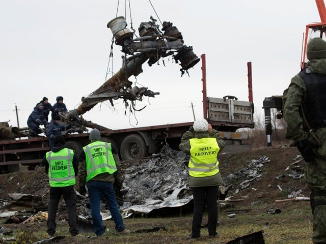members of the dutch export team watch as parts of the wreckage of the malaysia airlines flight mh17 are removed and loaded on a truck at the crash site near the village of grabove in eastern ukraine on november 16 2014 photo afp members of the dutch export team watch as parts of the wreckage of the malaysia airlines flight mh17 are removed and loaded on a truck at the crash site near the village of grabove in eastern ukraine on november 16 2014 photo afp