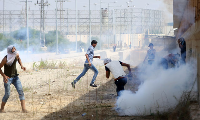 palestinian protesters clash with israeli security forces next to the border fence with israel on october 13 2015 at the erez crossing in the northern gaza strip photo afp