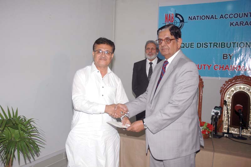 nab deputy chairperson rear admiral retd saeed ahmed sargana hands over a cheque to a representative of the sindh government photo press release