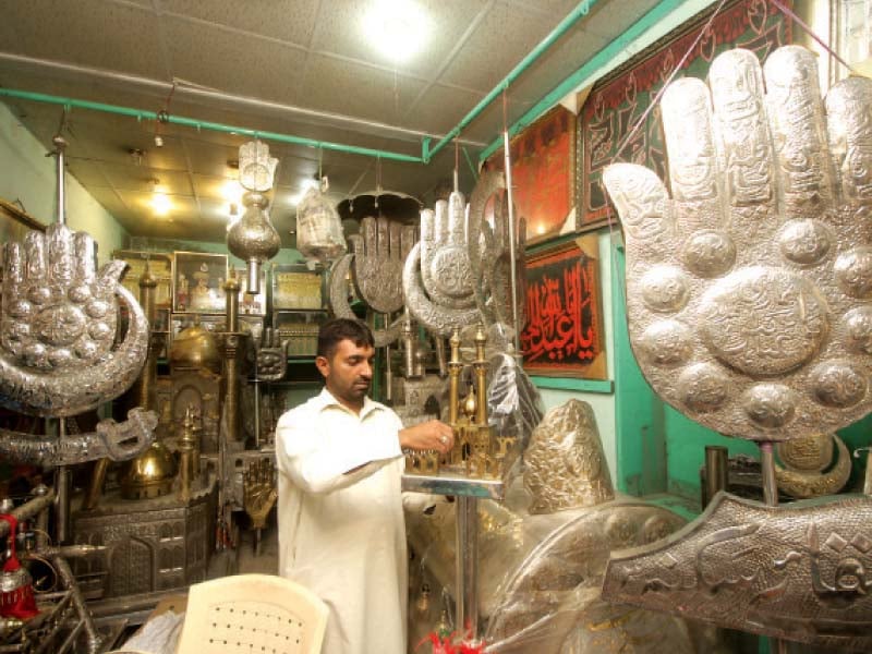 a shopkeeper near bibi pak daman shrine arranges a decoration piece photo abid nawaz express