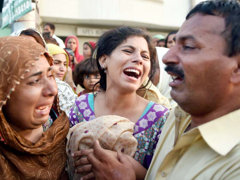 relatives mourn the death of their family members in a landslide in karachi photo afp