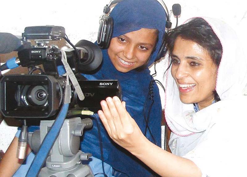 samar shares a light moment with a girl during a shoot photo samar minallah