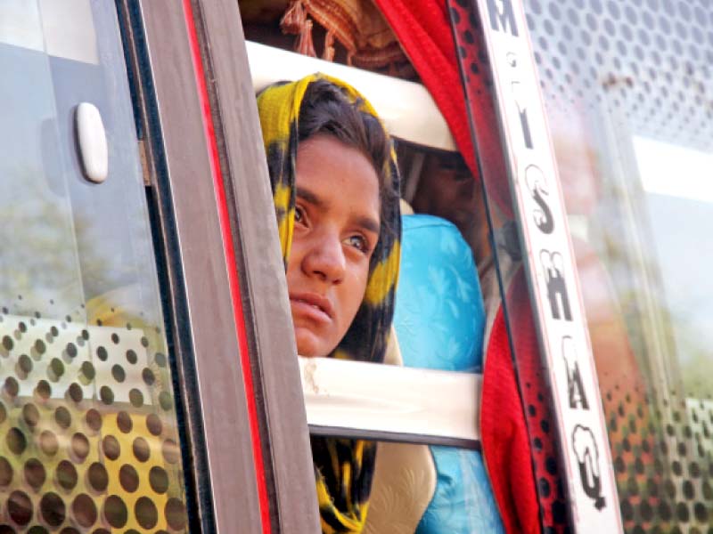 a young girl looks out the window of the bus she is taking with her family as they evacuated the site where the landslide took place photo athar khan express