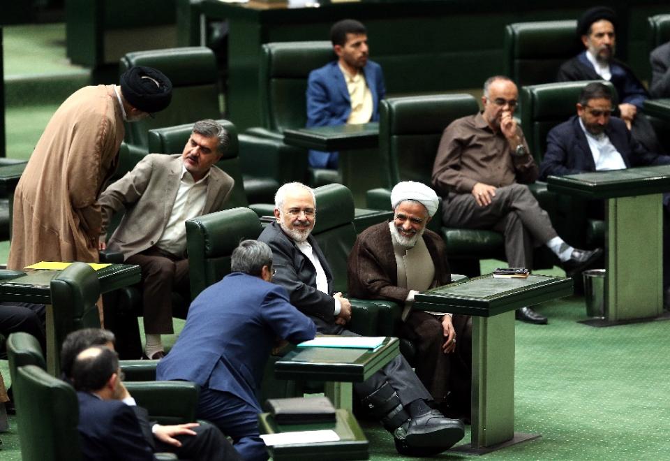 iranian foreign minister mohammad javad zarif c smiles as he chats with parliament members during a session in tehran on october 13 2015 in which parliament approved its nuclear deal with world powers photo afp