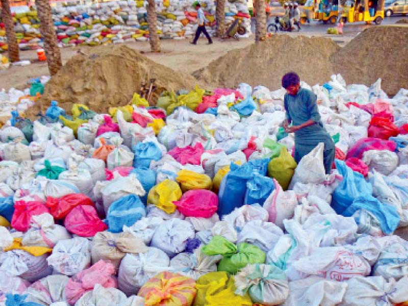 a man fills up sand bags at numaish chowrangi which will be placed along the route of the muharram processions for security purposes law enforcers claim to have made fool proof arrangements for muharram photo inp