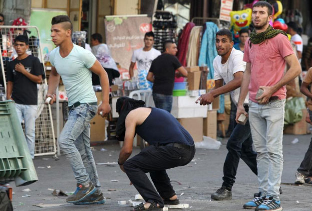 palestinian demonstraters collect stones to throw at israeli security forces during clashes in an area controlled by the palestinian authority in the centre of the west bank city of hebron on september 23 2015 photo afp