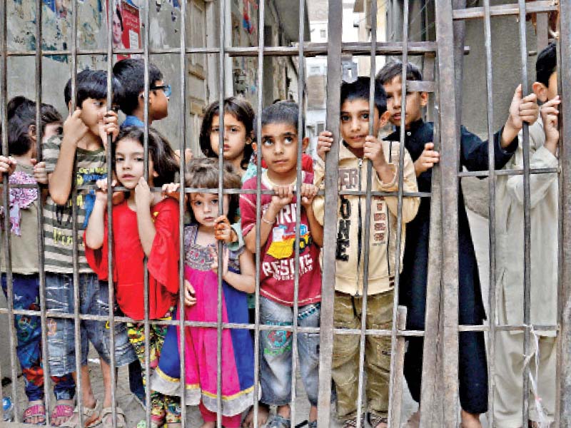 children look at muharram procession that starts in yakatoot and ends in mohallah khudadad at agha mustafa imambargah in the city photo muhammad iqbal express