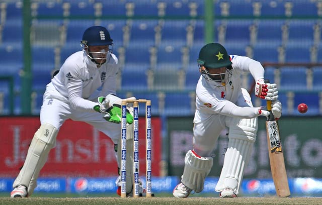 pakistan 039 s mohammad hafeez r is watched by england 039 s wicketkeeper jos buttler as he plays a shot during the fifth and final day 039 s play of the first cricket test match between pakistan and england at the sheikh zayed international cricket stadium in abu dhabi on october 17 2015 photo afp