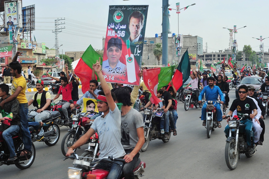 in this file photo activists of pti carry posters and wave flags as they drive through streets photo afp