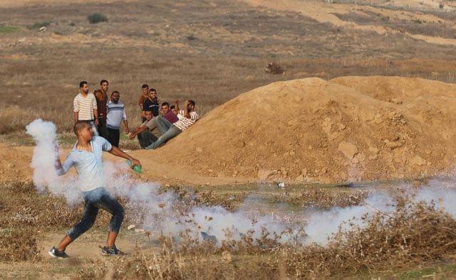a palestinian protester hurls back a tear gas canister fired by israeli troops during clashes near the border between israel and central gaza strip october 18 2015 photo reuters a palestinian protester hurls back a tear gas canister fired by israeli troops during clashes near the border between israel and central gaza strip october 18 2015 photo reuters