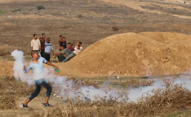 a palestinian protester hurls back a tear gas canister fired by israeli troops during clashes near the border between israel and central gaza strip october 18 2015 photo reuters a palestinian protester hurls back a tear gas canister fired by israeli troops during clashes near the border between israel and central gaza strip october 18 2015 photo reuters