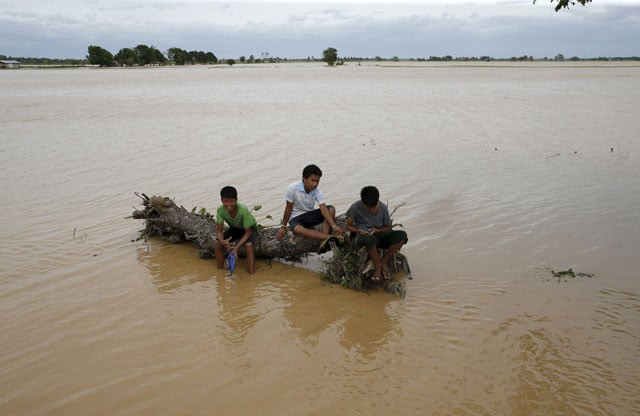 boys rest on a huge tree trunk swept by typhoon koppu in a flooded village of sta rosa nueva ecija in northern philippines october 19 2015 photo reuters boys rest on a huge tree trunk swept by typhoon koppu in a flooded village of sta rosa nueva ecija in northern philippines october 19 2015 photo reuters