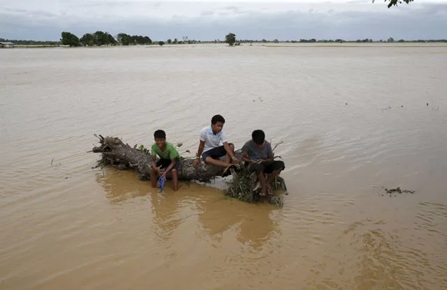 boys rest on a huge tree trunk swept by typhoon koppu in a flooded village of sta rosa nueva ecija in northern philippines october 19 2015 photo reuters boys rest on a huge tree trunk swept by typhoon koppu in a flooded village of sta rosa nueva ecija in northern philippines october 19 2015 photo reuters