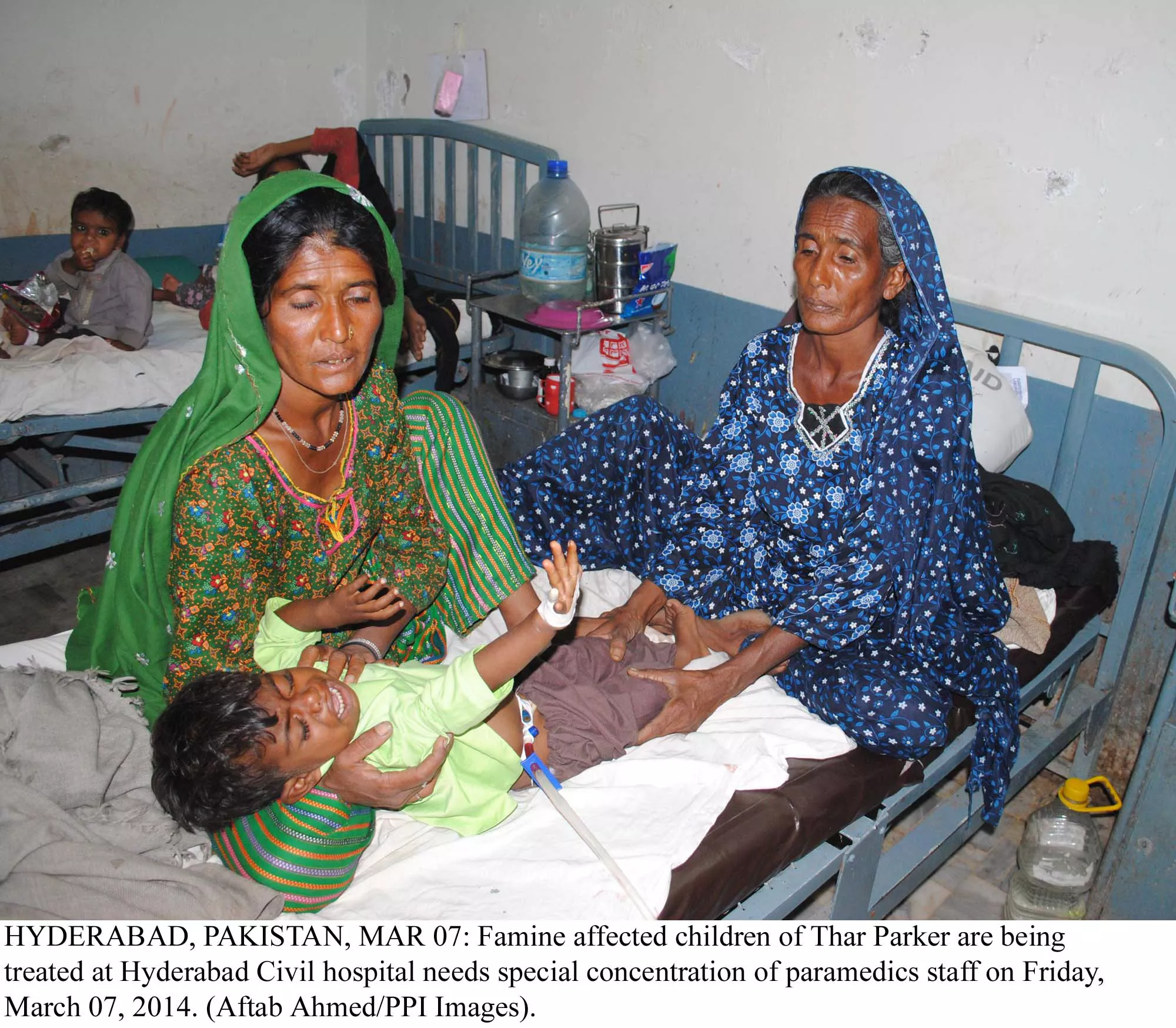 two women from thar watch as a child cries out photo ppi two women from thar watch as a child cries out photo ppi