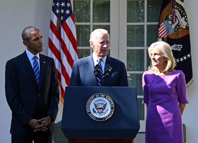 us vice president joe biden c flanked by us president barack obama l and his wife jill biden r speaks in the rose garden at the white house on october 21 2015 in washington dc photo afp