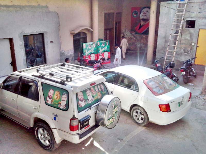 cars in the yard plastered with pti and pml n posters photo abid nawaz express