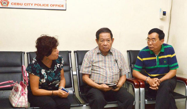a chinese consular officer left and her hand cuffed husband right will return to china after being held in the philippines for the shooting of chinese consul general song ronghua photo afp