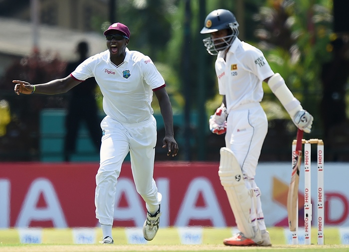 jason holder l celebrates after dismissing sri lankan cricketer kaushal silva r on october 22 2015 photo afp