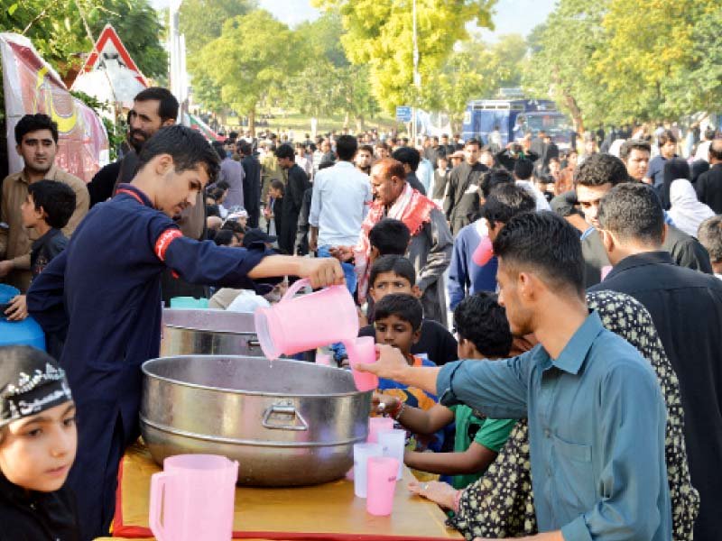 a view of the main procession at the asna ashri imambargah in g 6 top while a boy gives out drinks to participants photos muhammad javaid mudassar raja express